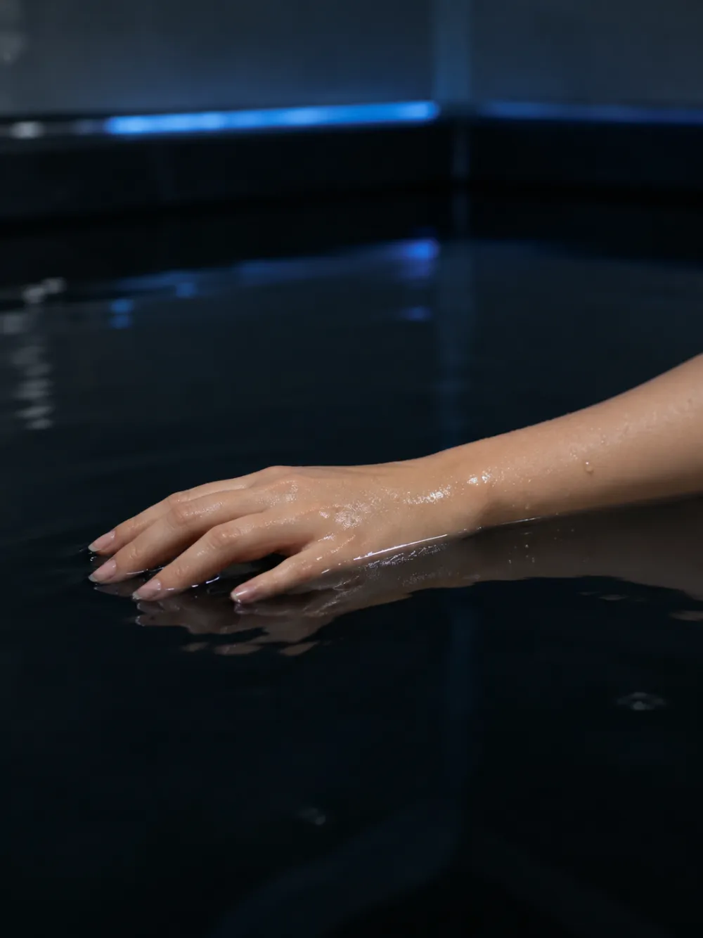 Bàn tay thả lỏng trên mặt nước muối Epsom – A relaxed hand resting on the Epsom salt water