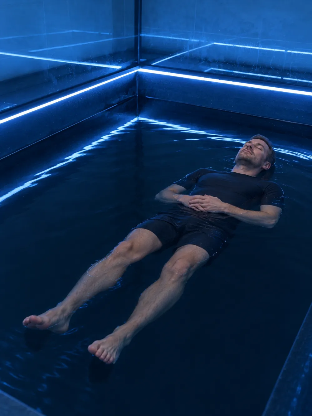 Người đàn ông nằm nổi, hai tay đặt nhẹ trên bụng – A man floating with his hands resting on his stomach